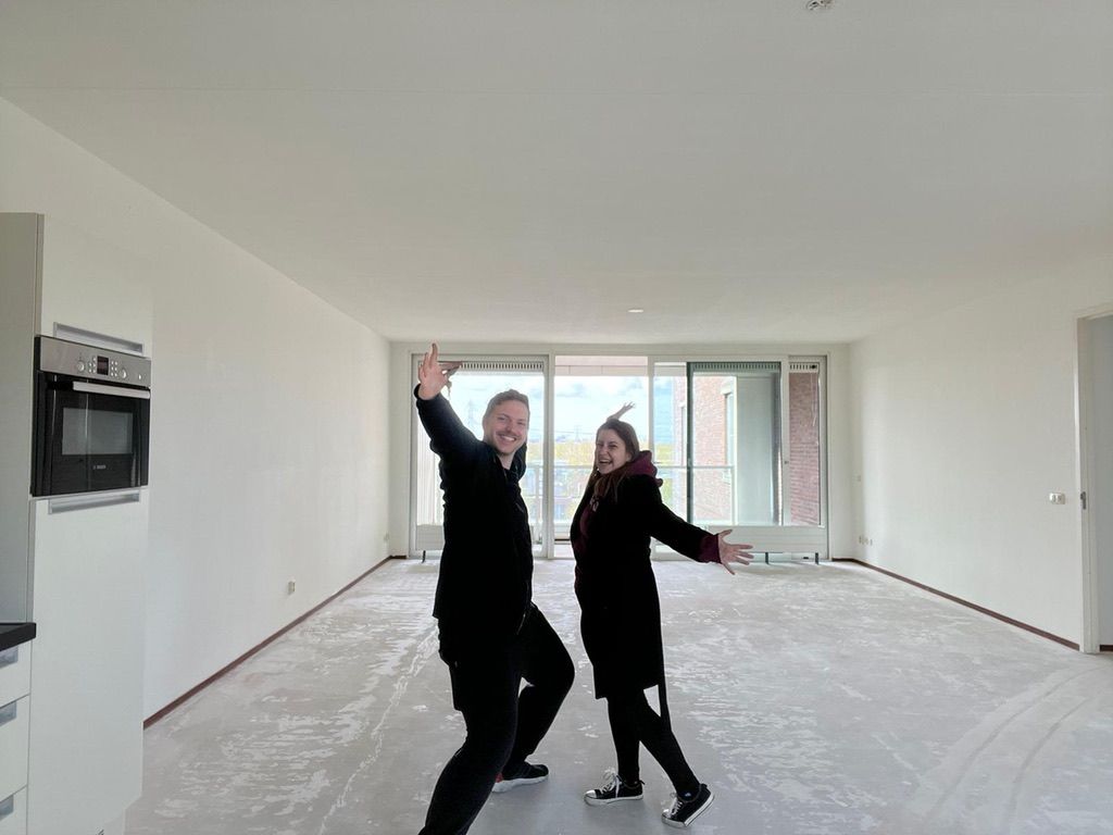 Niki and me standing in our apartment without flooring, but with the keys!